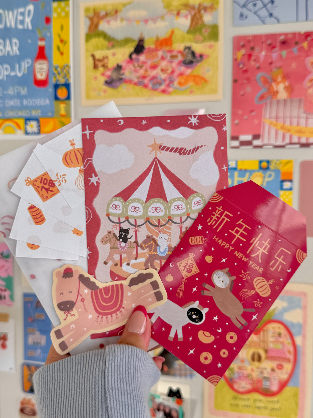 Hand holding colorful postcards, stickers, and envelopes with cute cat and horse designs and festive Chinese New Year themes, showcasing the February 2026 edition of Cherry Miso Post.