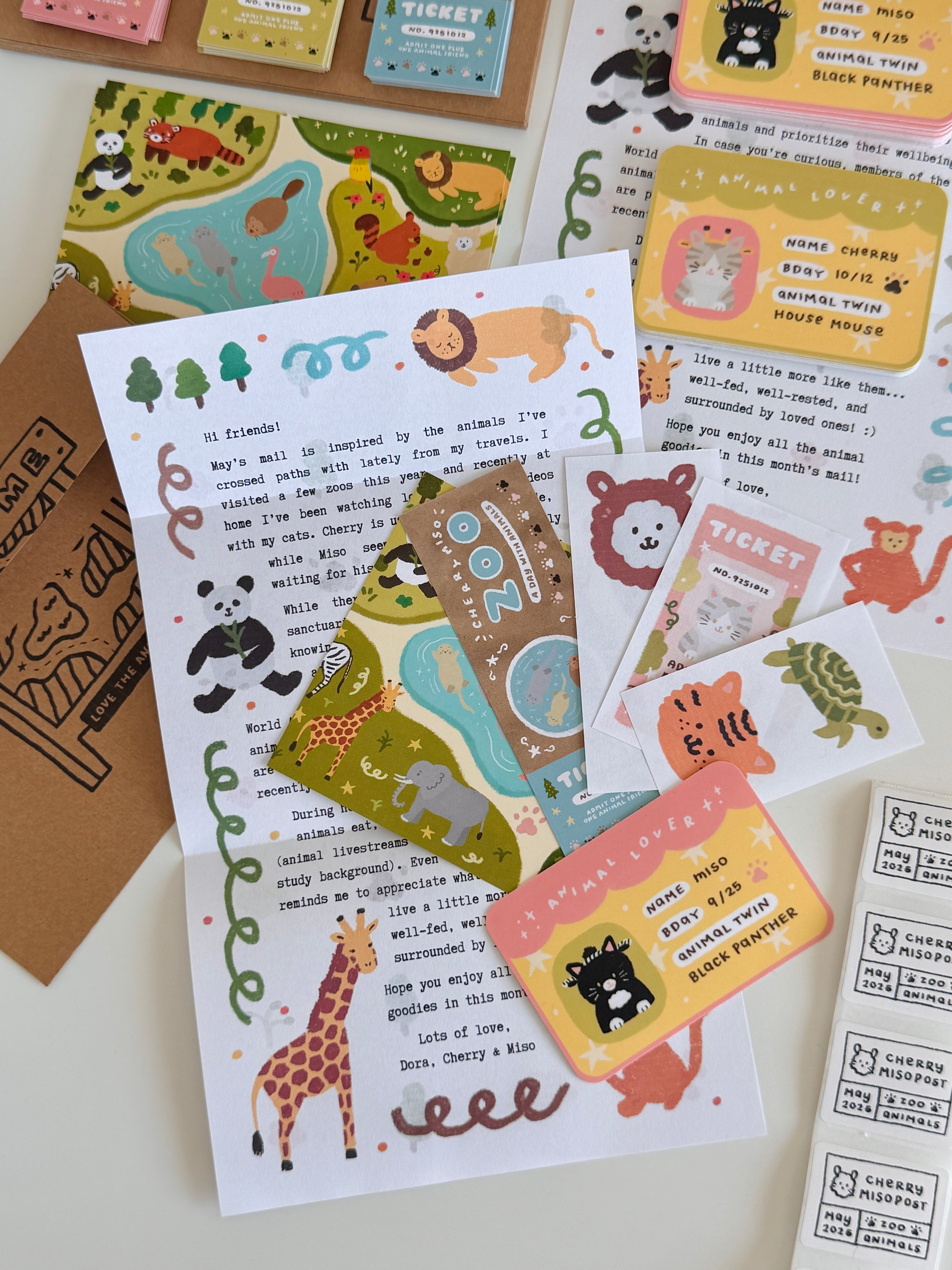 Flat lay of colorful stationery featuring animal-themed postcards, stickers, and a letter with cute illustrations, part of May edition of Cherry Miso Post.